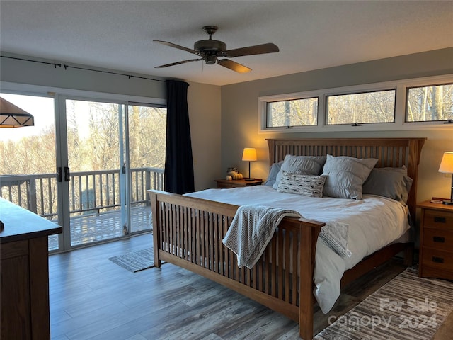 bedroom featuring wood-type flooring, access to outside, multiple windows, and ceiling fan