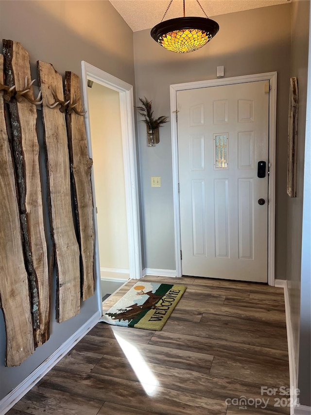 entrance foyer with a textured ceiling and dark hardwood / wood-style flooring