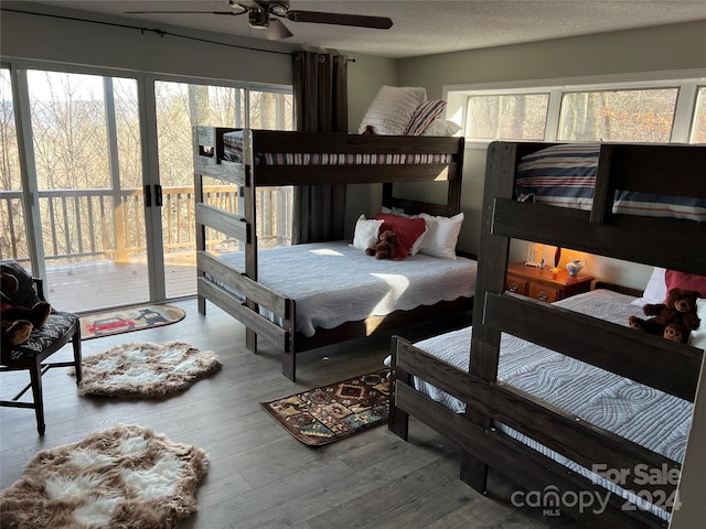 bedroom with multiple windows, ceiling fan, a textured ceiling, and hardwood / wood-style flooring