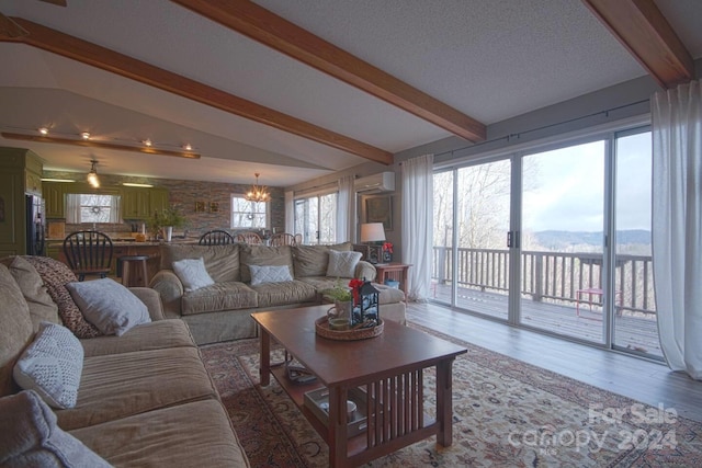 living room featuring an AC wall unit, a chandelier, lofted ceiling with beams, and wood-type flooring