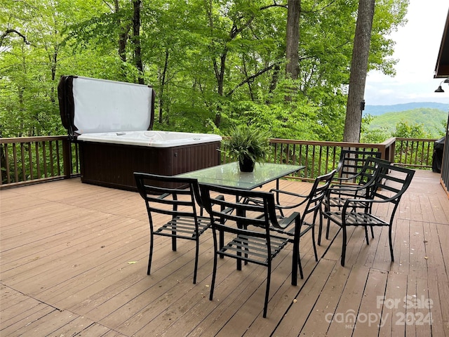 wooden deck featuring a mountain view and a hot tub