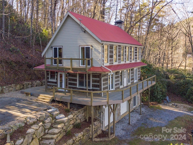 rear view of property with a sunroom and a deck