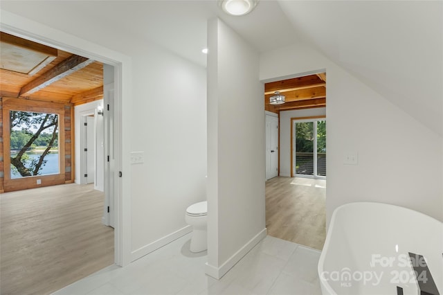 bathroom with a washtub, wood-type flooring, plenty of natural light, and wood ceiling