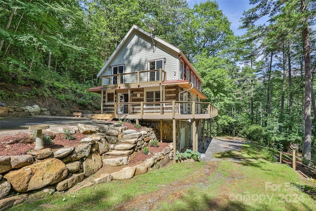 1679 Woods Mountain Trl, Cullowhee, NC 28723 - view of front facade featuring a wooden deck, stone siding, and a forest view
