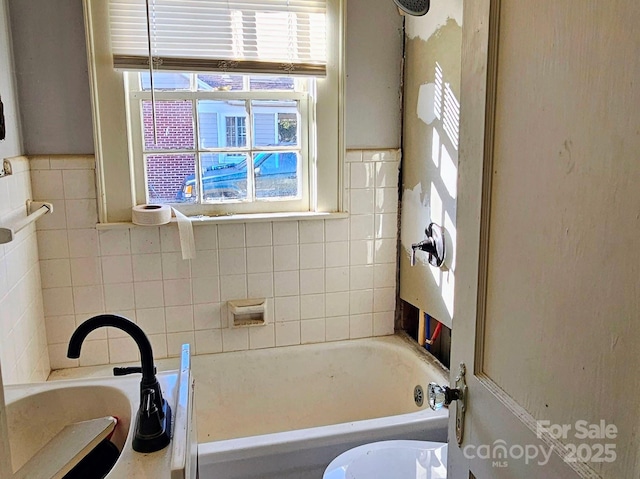 bathroom with sink and a tub to relax in