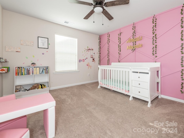 carpeted bedroom with a nursery area and ceiling fan