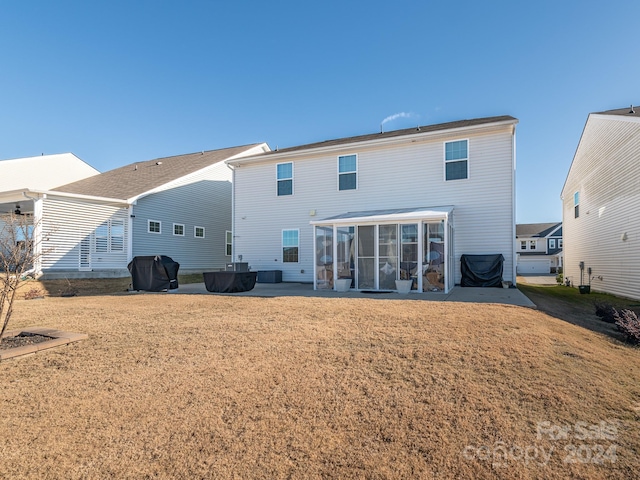 back of house with a sunroom and a lawn