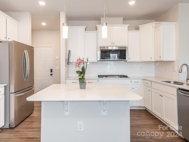 kitchen featuring sink, dark hardwood / wood-style floors, decorative light fixtures, white cabinetry, and stainless steel appliances