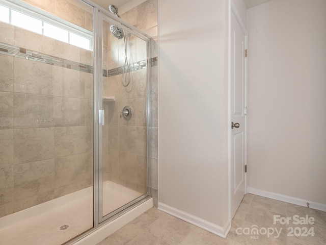 bathroom with tile patterned floors and a shower with shower door