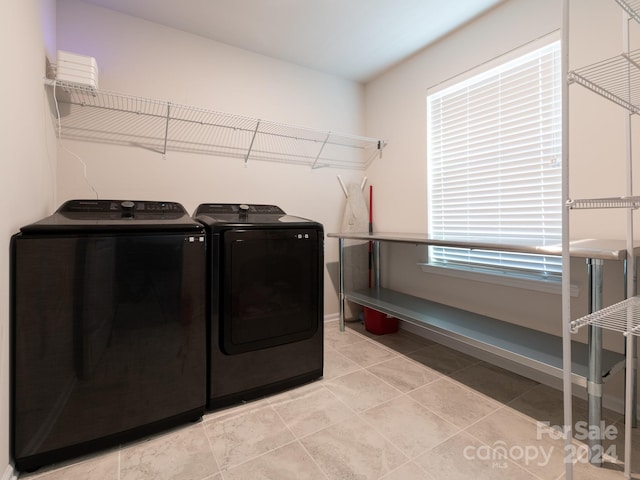 laundry area featuring light tile patterned floors and washer and clothes dryer