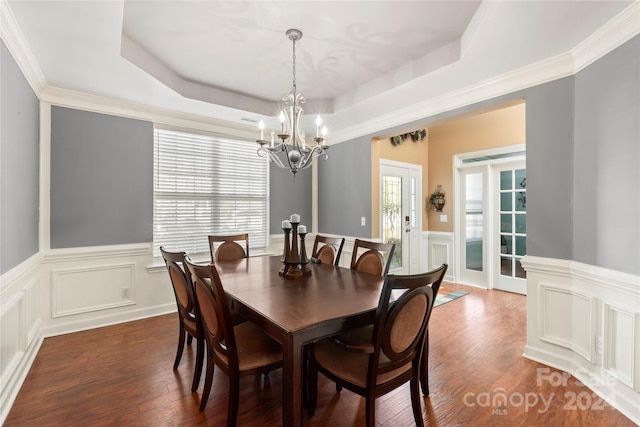 dining room featuring plenty of natural light, dark hardwood / wood-style floors, and a tray ceiling