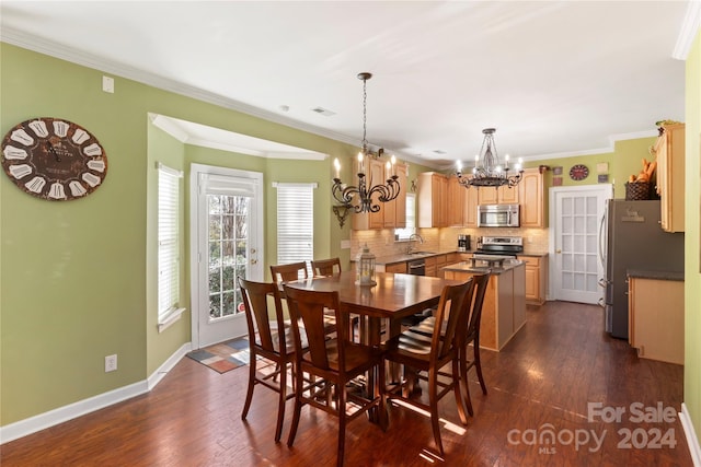 dining room featuring a notable chandelier, dark hardwood / wood-style floors, ornamental molding, and sink