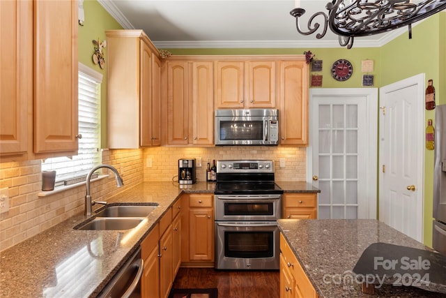 kitchen with dark stone countertops, a wealth of natural light, sink, and appliances with stainless steel finishes