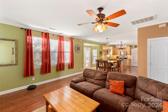 living room with hardwood / wood-style floors, ceiling fan with notable chandelier, and crown molding