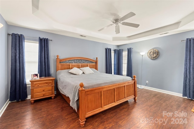 bedroom featuring a tray ceiling, ceiling fan, and dark hardwood / wood-style floors