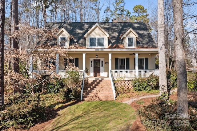 cape cod home with a front yard and a porch