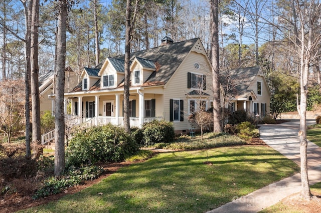 new england style home with a porch and a front lawn