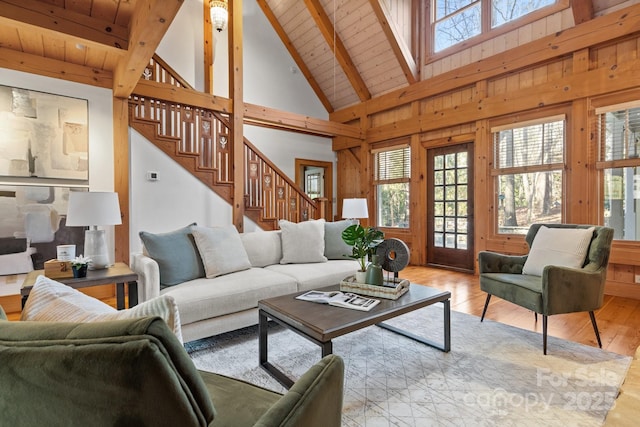 living room featuring beam ceiling, wood ceiling, light hardwood / wood-style flooring, and wood walls