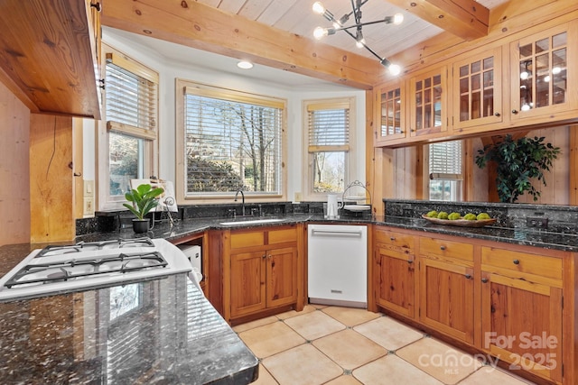 kitchen with wooden ceiling, beam ceiling, sink, and dark stone countertops