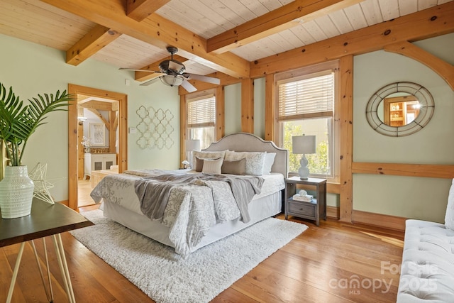 bedroom with wood ceiling, light hardwood / wood-style flooring, ensuite bath, and beamed ceiling