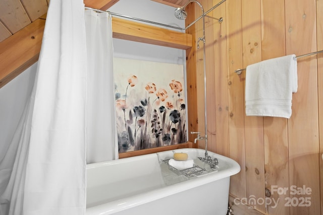 bathroom featuring shower / tub combo and wood walls