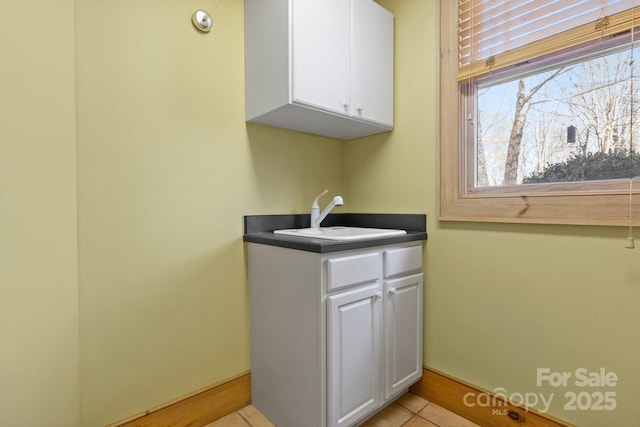 clothes washing area with sink and light tile patterned floors