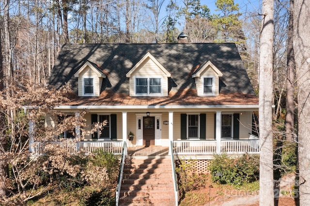 cape cod house featuring covered porch