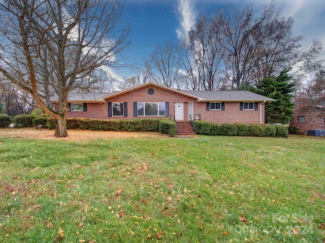 ranch-style home with cooling unit and a front yard