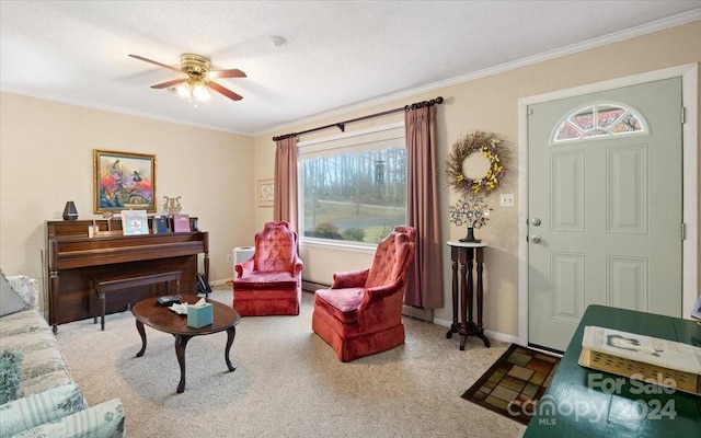 living area featuring carpet flooring, ceiling fan, ornamental molding, and a baseboard heating unit