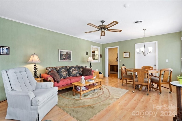 living room with ceiling fan with notable chandelier, light hardwood / wood-style floors, and crown molding