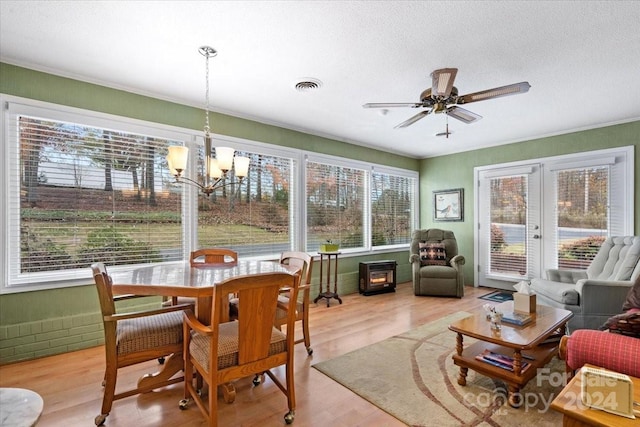 sunroom / solarium featuring french doors and ceiling fan with notable chandelier