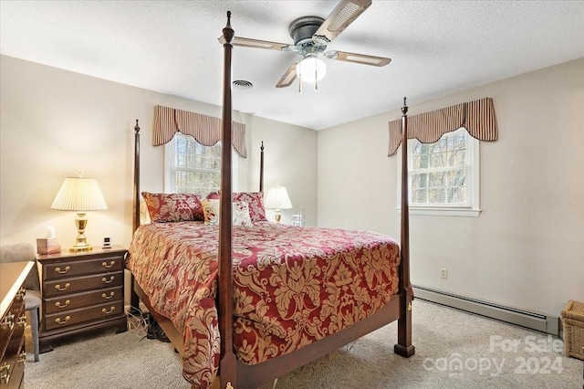 carpeted bedroom with a textured ceiling, ceiling fan, multiple windows, and a baseboard heating unit