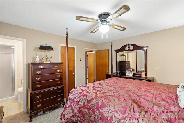 bedroom with ceiling fan, ensuite bathroom, and light carpet