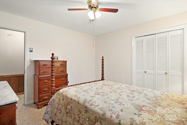 bedroom with ceiling fan, light colored carpet, and a textured ceiling