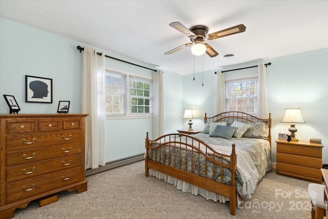 carpeted bedroom featuring a baseboard radiator and ceiling fan