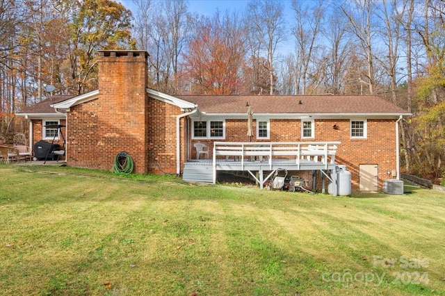 rear view of house featuring a yard, cooling unit, and a deck