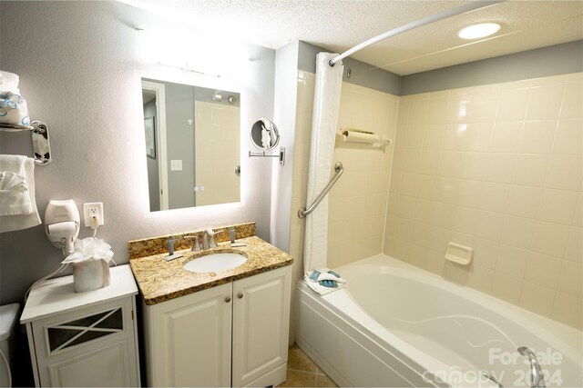 bathroom with shower / bath combo with shower curtain, vanity, and a textured ceiling