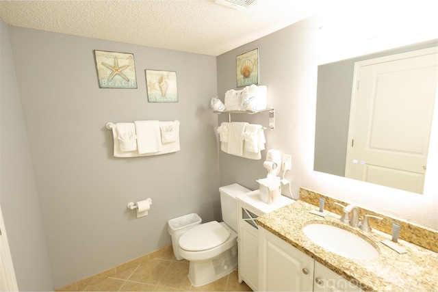 bathroom with tile patterned flooring, vanity, a textured ceiling, and toilet