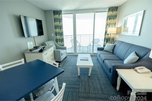 carpeted living room featuring floor to ceiling windows and a textured ceiling