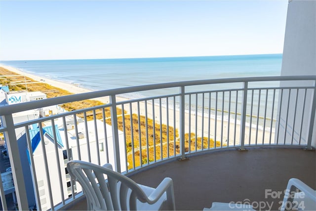 balcony featuring a view of the beach and a water view