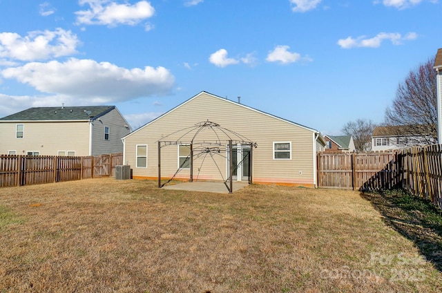 rear view of property with a gazebo, central AC, a patio area, and a lawn