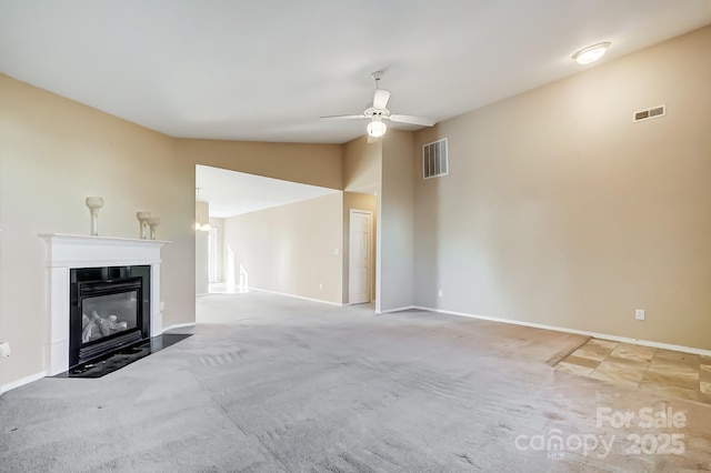 unfurnished living room featuring ceiling fan, light colored carpet, and vaulted ceiling