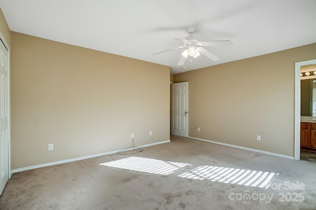 unfurnished bedroom featuring light carpet, connected bathroom, and ceiling fan