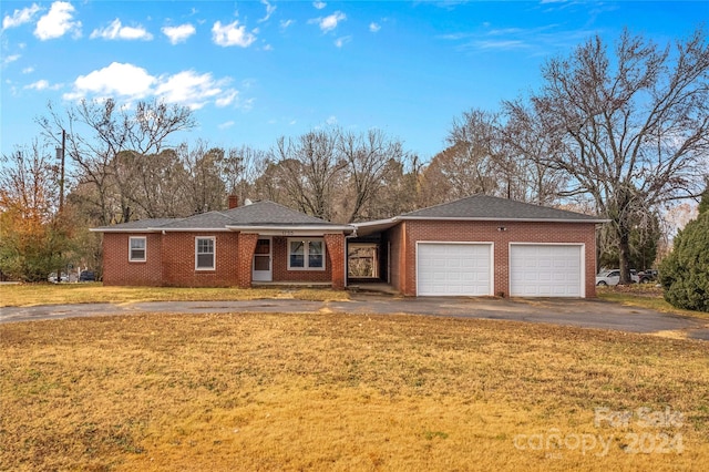 ranch-style home with a garage and a front lawn