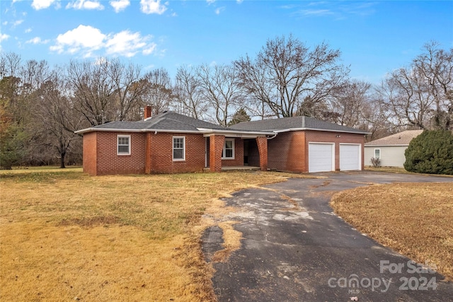 single story home featuring a garage and a front lawn