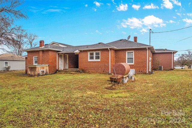 rear view of property featuring a lawn