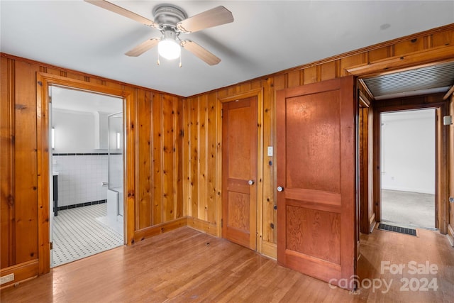 hallway featuring wood walls and light hardwood / wood-style floors