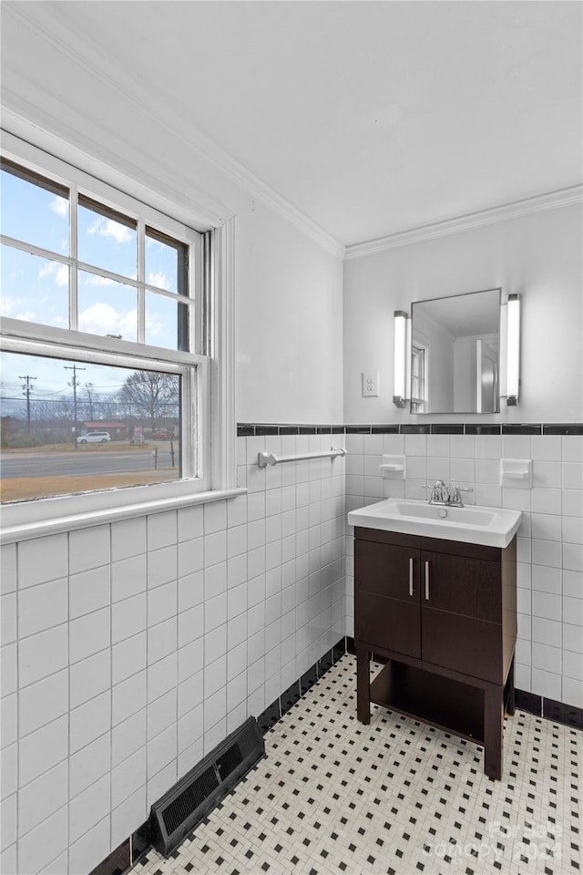 bathroom with tile patterned flooring, vanity, and tile walls