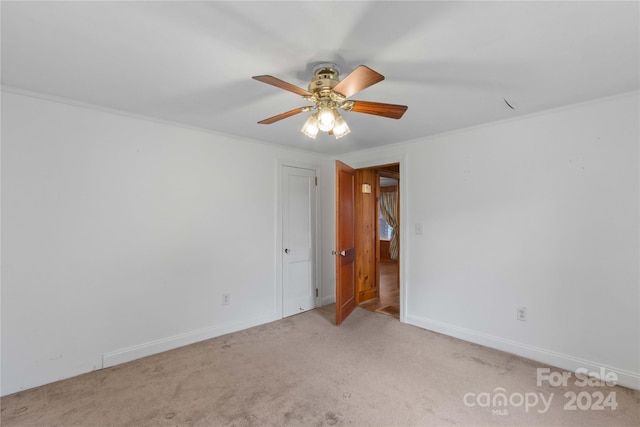 unfurnished room featuring light carpet, ceiling fan, and ornamental molding