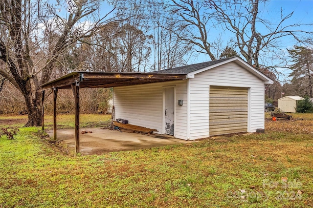 garage featuring a yard and a carport